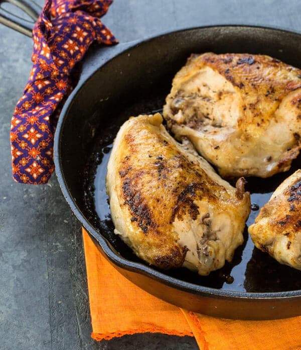 A pan filled with bone in chicken breasts.