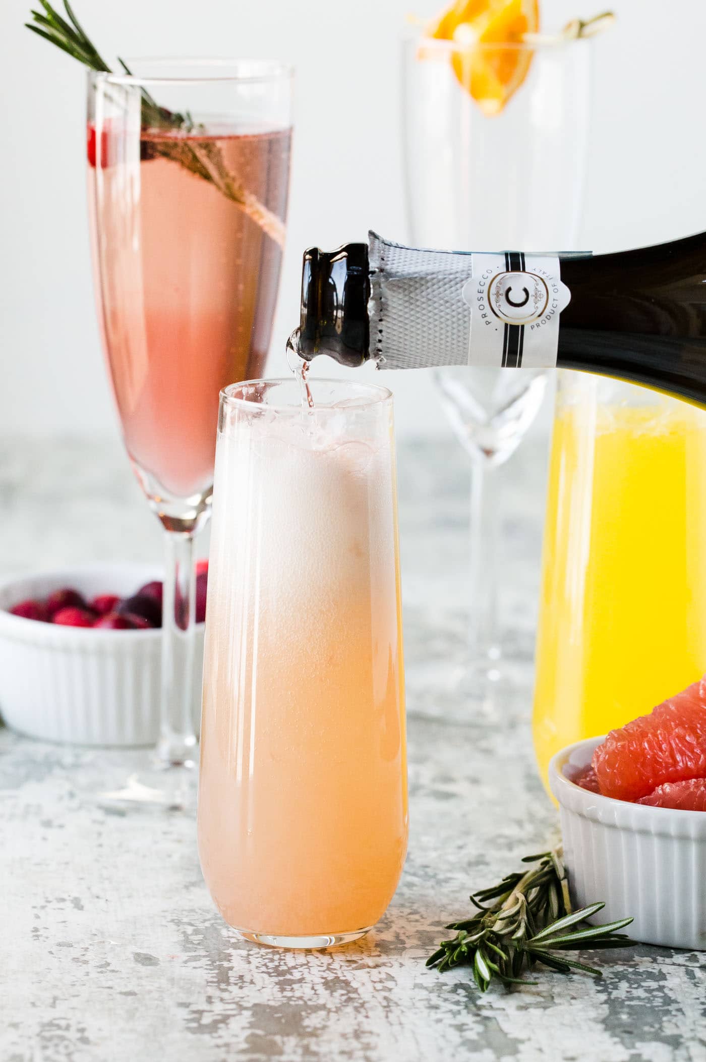 A glass of juice with Prosecco being poured into.