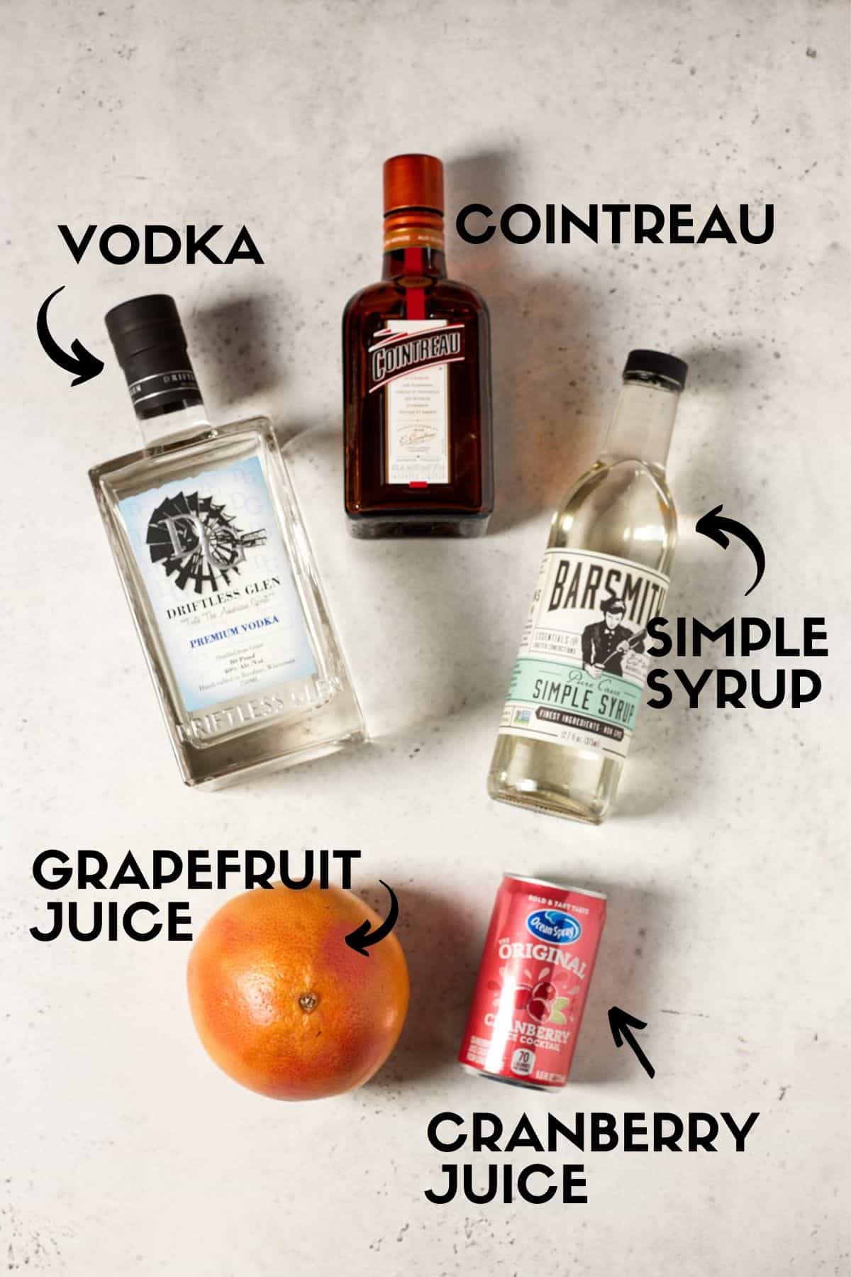 Bottles of vodka, cointreau, simple syrup, cranberry juice and a grapefruit. 